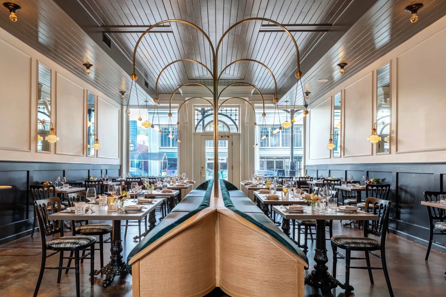 The Lola dining room at the National Exchange Hotel, with brass arches and a green velvet booth